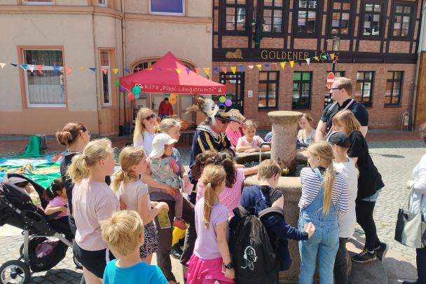 Kinder stehen um einen Brunnen