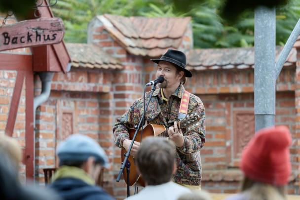 Ein Musiker mit Gitarre spielt im Museumshof