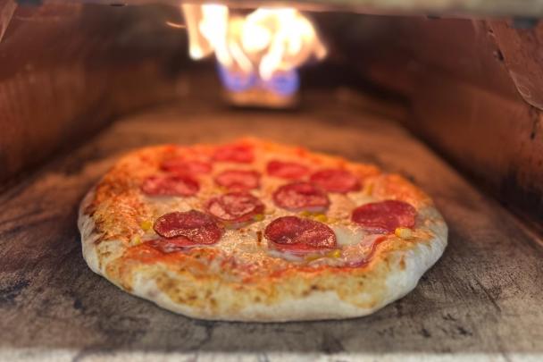 Eine Pizza bäckt in einem Pizzaofen.