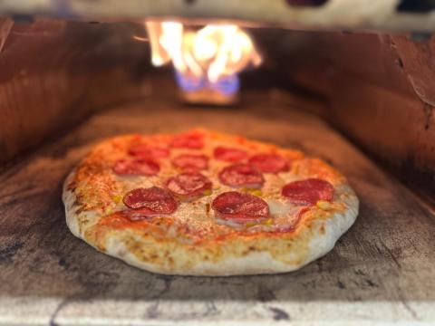 Eine Pizza bäckt in einem Pizzaofen.